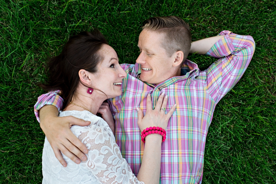 A man holds his fiance while they lay in the grass during their philadelphia engagement session.